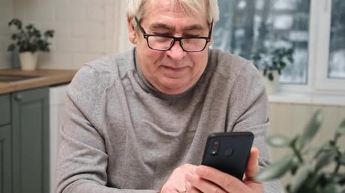 Mature Adult Using Mobile Phone Indoors