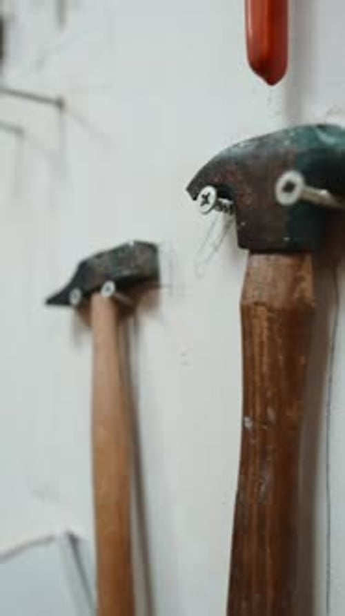 Various Hammers Hanging on a White Wall in a Carpentry Workshop
