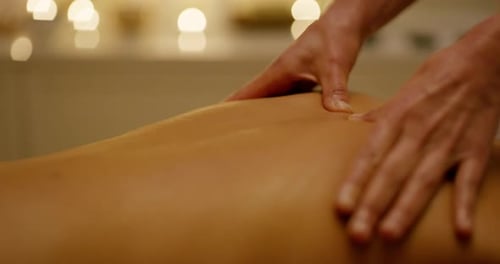 A young woman getting a back massage at a day spa