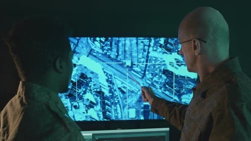 Figures Working on Techy Screen in Dark Room