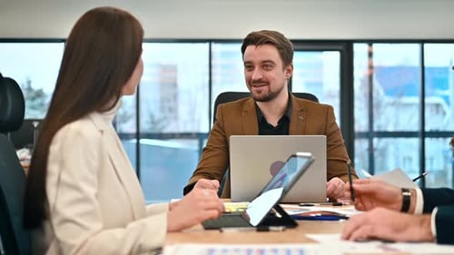 Business meeting in an office, workers discussing business affairs. Gadgets and papers on the table.