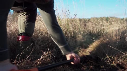 Shoveling Soil With Dry Reeds On The Field For Greenhouse. closeup shot