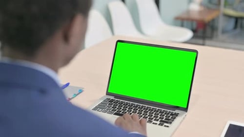 Young African Businessman Using Laptop with Green Screen