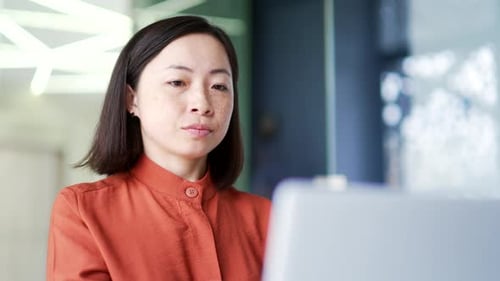 Close up Thoughtful serious Asian businesswoman is thinking about solving a problem while working