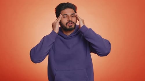 Young Man Rubbing Temples in Frustration