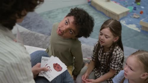 Diverse Kids Talking to Teacher while Learning Letters with Cards