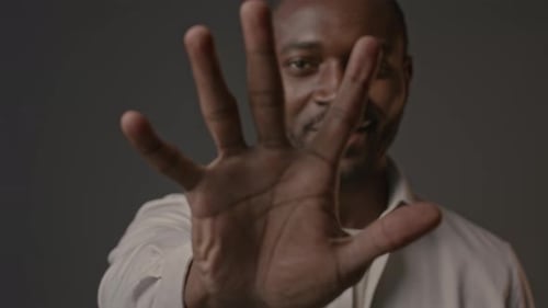 Black Man Showing Palm at Camera