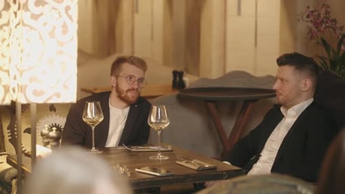 Zwei Geschäftsleute, die sich im Restaurant ausruhen, reden und diskutieren über Geschäfte und trinken am Wochenende Wein