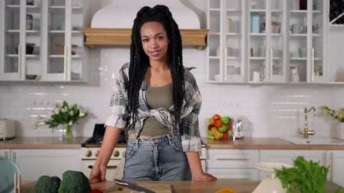Smiling Woman with Fresh Produce in Modern Kitchen