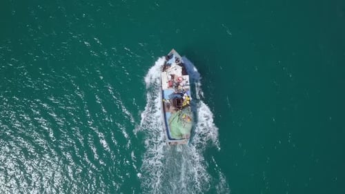 Small White fishing boat cruising slowly at The Mediterranean Sea