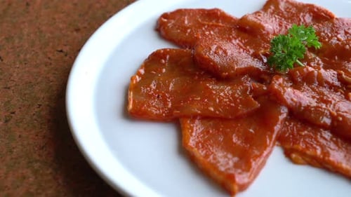 Prepared Raw Meat Slices with Vibrant Red Sauce