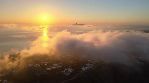 Amanecer aéreo sobre las nubes y el mar en la isla de Santorini, Grecia