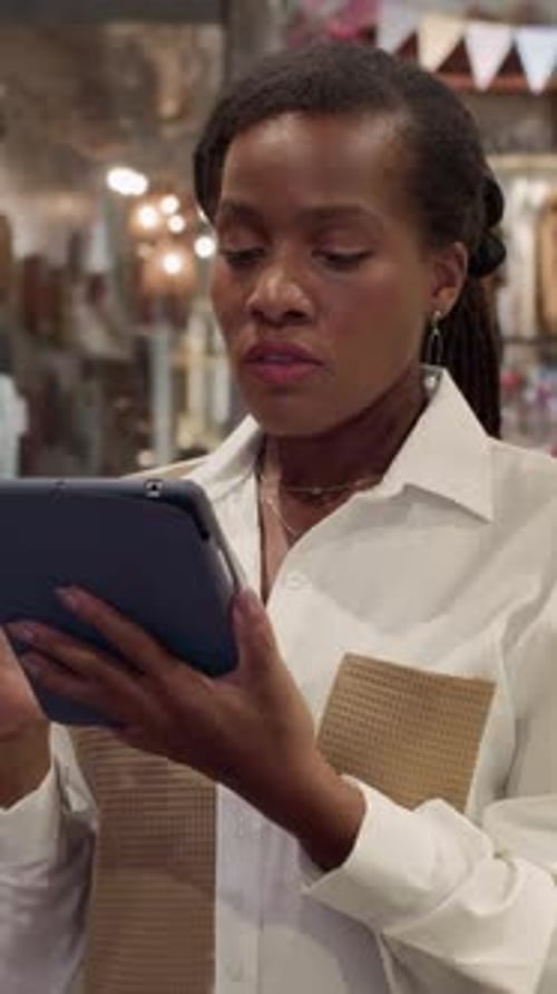 Female Specialist Analyzing Work Using Digital Tablet in Store
