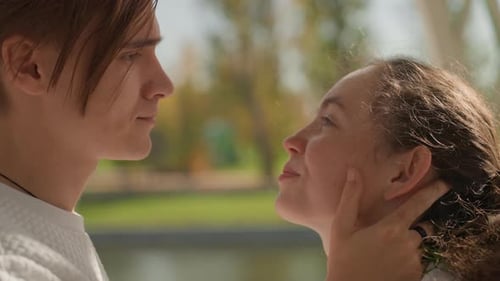 Couple Kissing in Gazebo Sunlight Intimate Embrace and Gentle Hands Emotional Gaze Park Pond