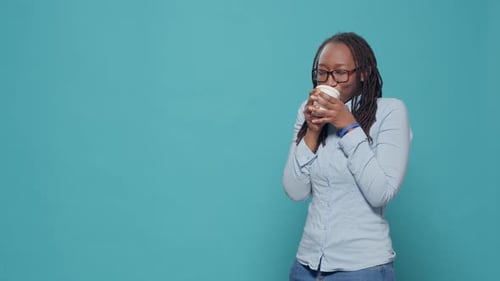 Smiling Woman Enjoys Coffee in Studio