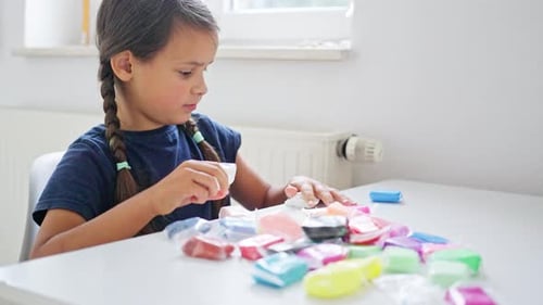A Happy Child is Joyfully Crafting with Vibrant and Colorful Modeling Clay in a Bright Inviting