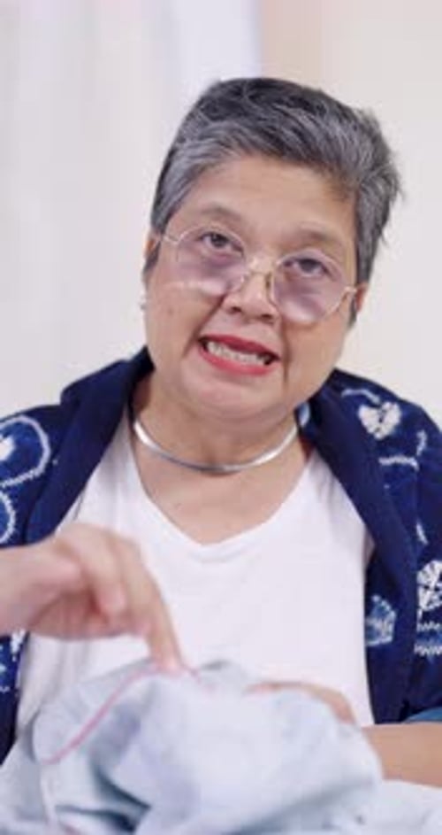 Woman with Gray Hair Sewing a Shirt
