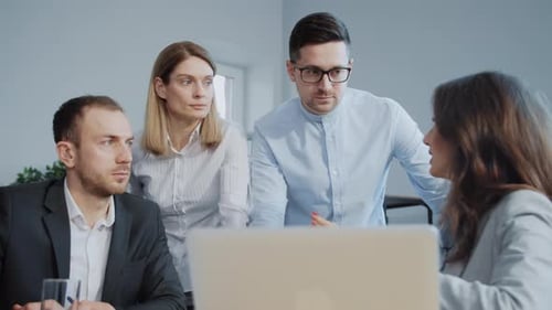 Business Team Collaborating on Laptop in Bright Office