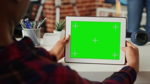 Female Freelancer Holding Digital Gadget with Horizontal Green Screen