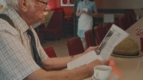 Grey Haired Gentleman Reading Morning Press at Retro Diner Counter