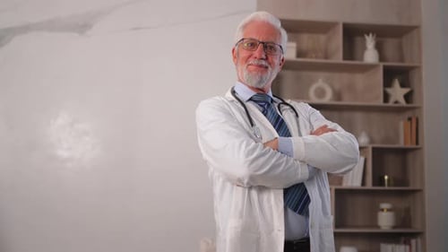 Mature Senior Male Doctor in Glasses Medical Uniform Smiling Looking at Camera in Hospital or Doctor