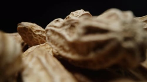 Makro-Nahaufnahme, isoliertes Filmmaterial von viel roher Erdnuss oder Erdnuss mit Schale und Schale als Zutat