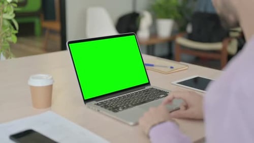 Man Using Laptop with Green Chroma Screen