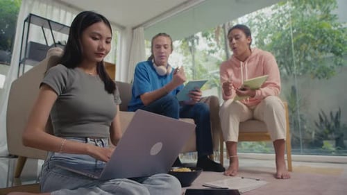 Three Students Collaborating on Project in Living Room