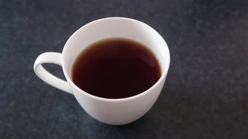 Milk being poured into a mug of coffee