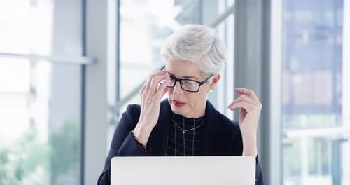 4k video footage of a mature businesswoman looking stressed out while working in an office