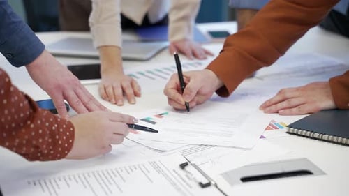 Close up of group of business people working on startup project at desk in business office. Team