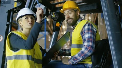 Female Supervisor Gives Work Assignment to Forklift Driver. They're in a Big Warehouse Full of Pall