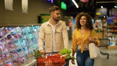 Casal feliz comprando mantimentos no supermercado