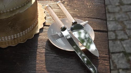 wedding cake with knife and fork on rustic wooden table