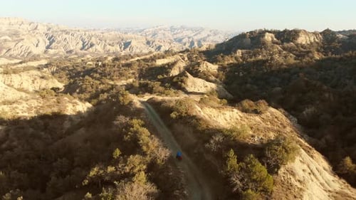Traveler Bicycle Touring On Gravel Road In The Mountains
