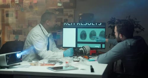 Scientists Reviewing Fingerprint Search Results in Dark Office