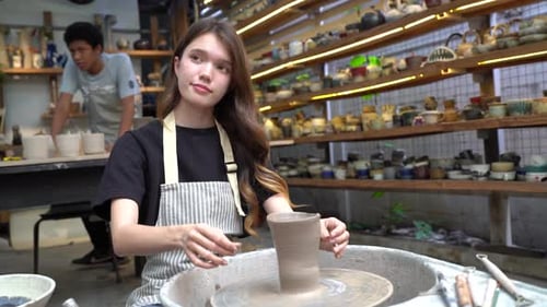 People Creating Pottery in Studio. Female artisan creating handmade ceramics in pottery workshop