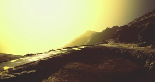 Golden Landscape with Winding Road and Distant Mountains at Sunset
