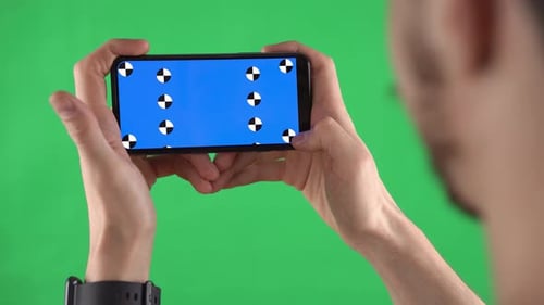 Person Taps Blue Screen on Smartphone with Green Screen