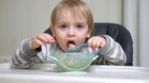 Cute Child Eating Food with a Spoon