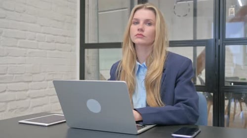 Young Woman Working on Laptop in Modern Office