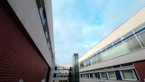 Wide Angle Modern Hospital Building with Glass Windows and an Elevator Over Blue Sky