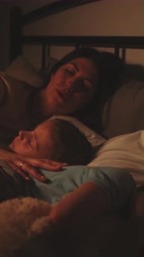 Loving Mother Cuddling Child at Bedtime