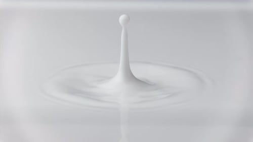 Photo macro au ralenti d'une goutte de lait frais tombant et éclaboussant dans une piscine laiteuse