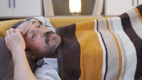 Nervous man thoughtful in bed.