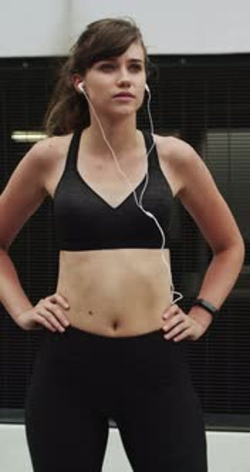 Runner, earphones and thinking with woman in city for streaming service, health podcast and cardio