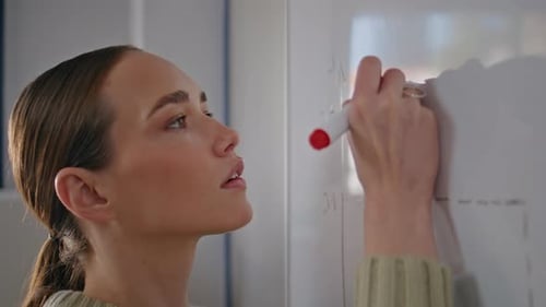 Woman Drawing Graph on Whiteboard in Office