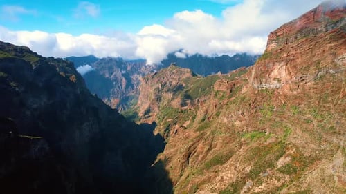 High mountains with poor vegetation lit with bright sun.