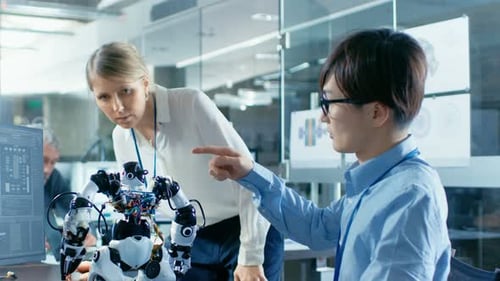 Der Programmierer programmiert den Roboter und spricht mit dem Chefingenieur. Sie arbeiten in einem wissenschaftlich fortgeschrittenen Labor
