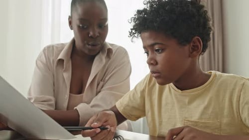 African American Mother Helping Son with School Homework